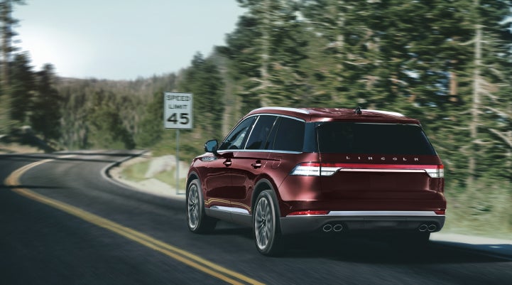 A 2024 Lincoln Aviator® SUV is being driven on a winding mountain road | Lincoln of Cutler Bay in Miami FL