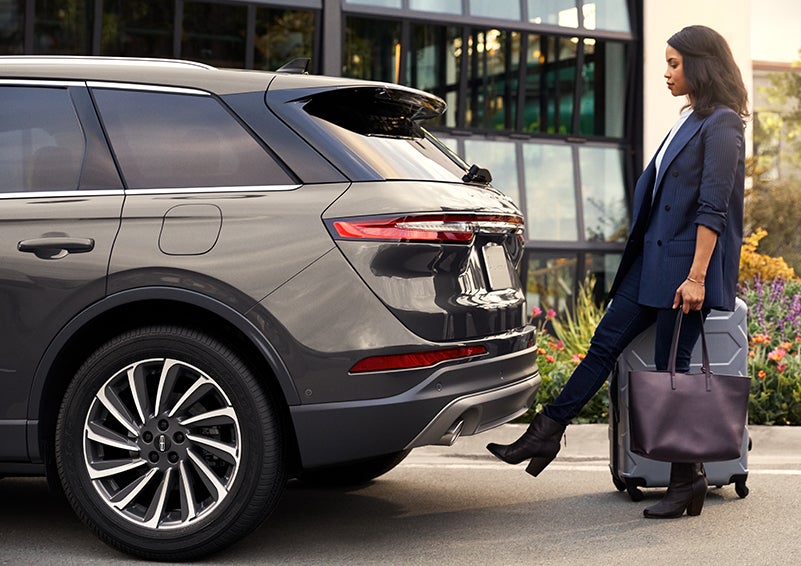 A woman with her hands full uses her foot to activate the available hands-free liftgate. | Lincoln of Cutler Bay in Miami FL