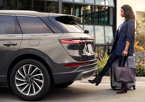 A woman with her hands full uses her foot to activate the available hands-free liftgate. | Lincoln of Cutler Bay in Miami FL