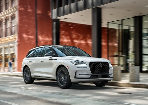 The 2024 Lincoln Corsair® SUV with the Jet Appearance Package and a Pristine White exterior is parked on a city street. | Lincoln of Cutler Bay in Miami FL