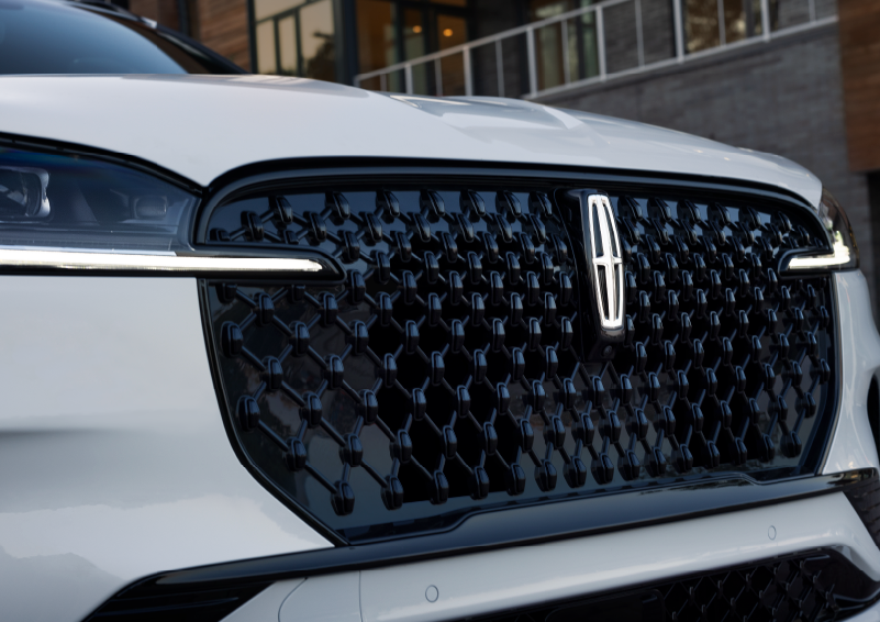 The black grille of a white 2025 Lincoln Aviator® SUV is shown with its fog lights on. | Lincoln of Cutler Bay in Miami FL