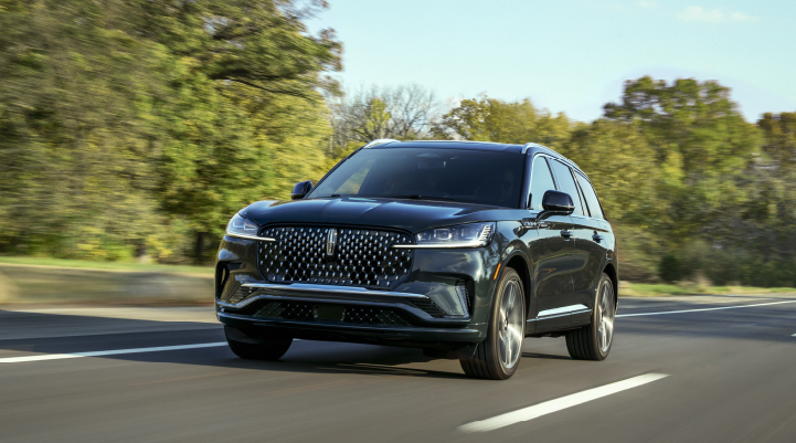 A 2025 Lincoln Black Label Aviator® SUV is being driven down a road lined with trees. | Lincoln of Cutler Bay in Miami FL